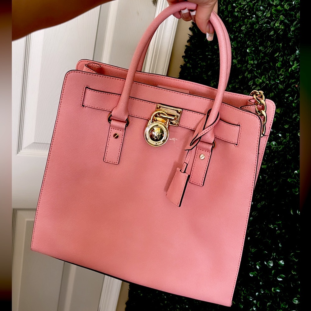 pink michael kors purse with gold accessories .